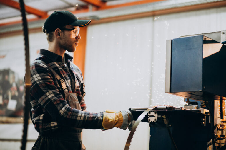 Hombre vestido de cuadros con la mano en una herramienta industrial